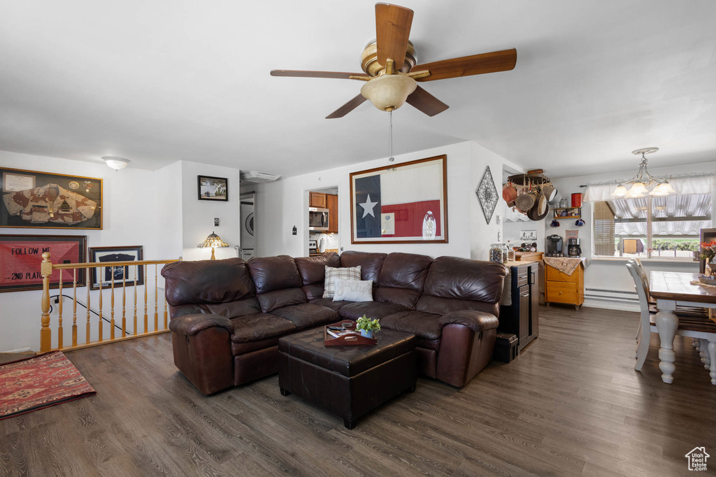 Living room featuring ceiling fan, a chandelier, wood finished floors, and washer / clothes dryer