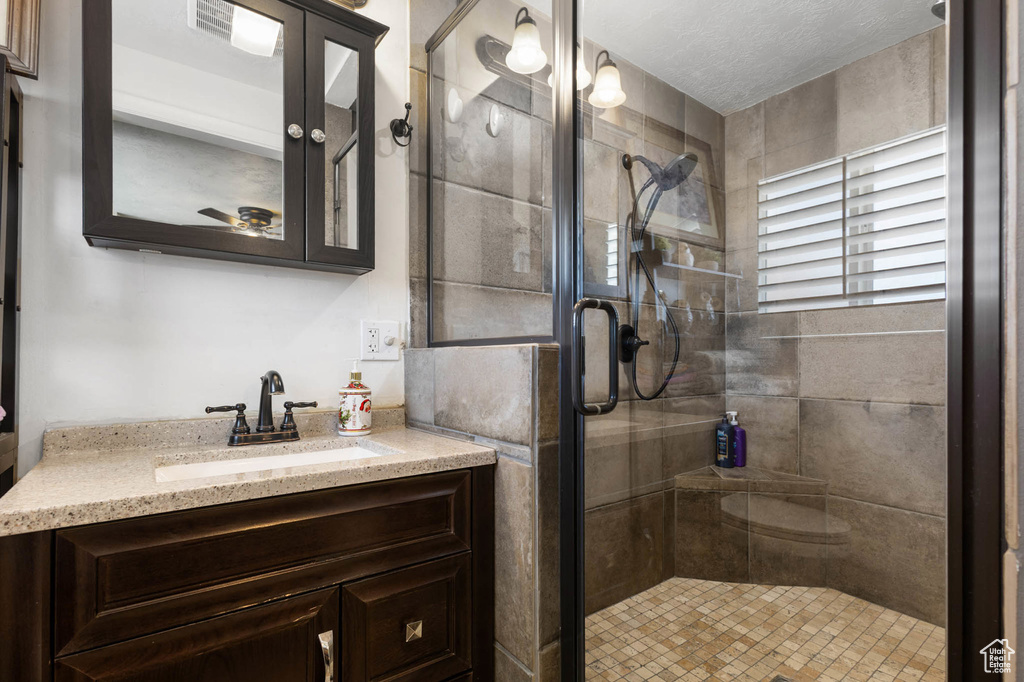 Bathroom featuring vanity and a shower stall