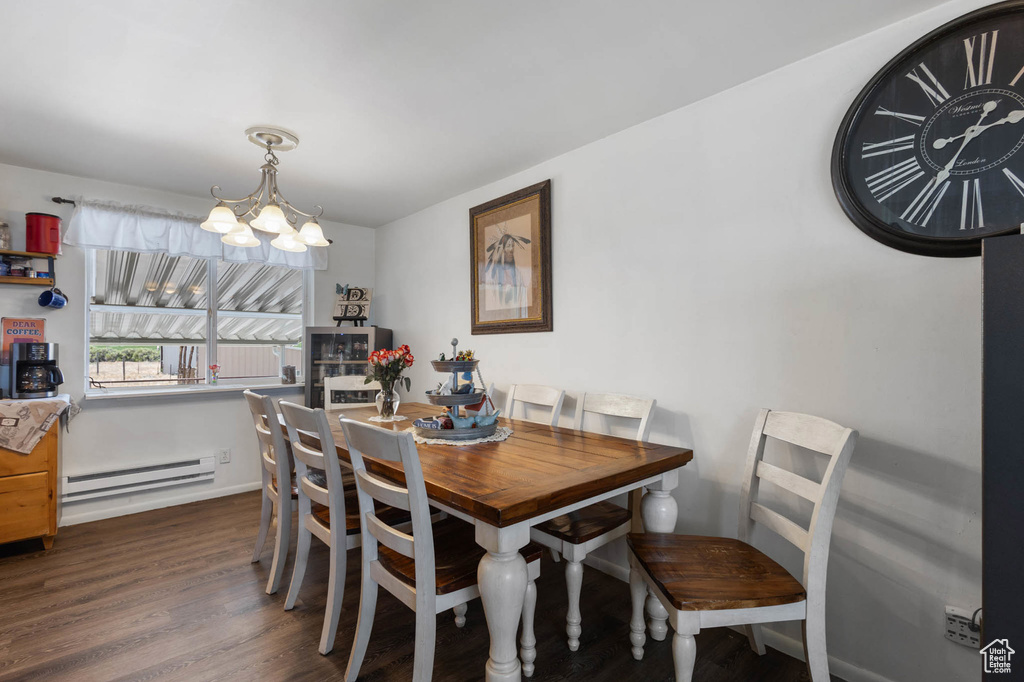 Dining area with baseboard heating, a chandelier, and dark wood-type flooring