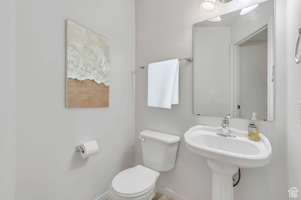 Half bath featuring toilet and baseboards
