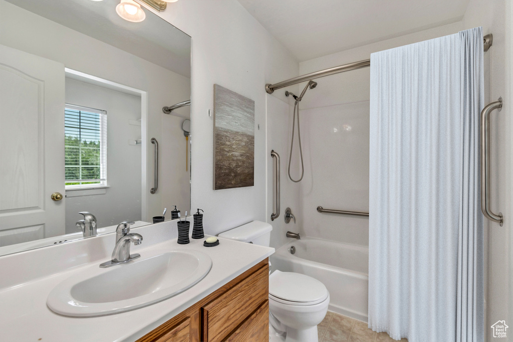 Bathroom with shower / bath combo with shower curtain, vanity, and tile patterned floors