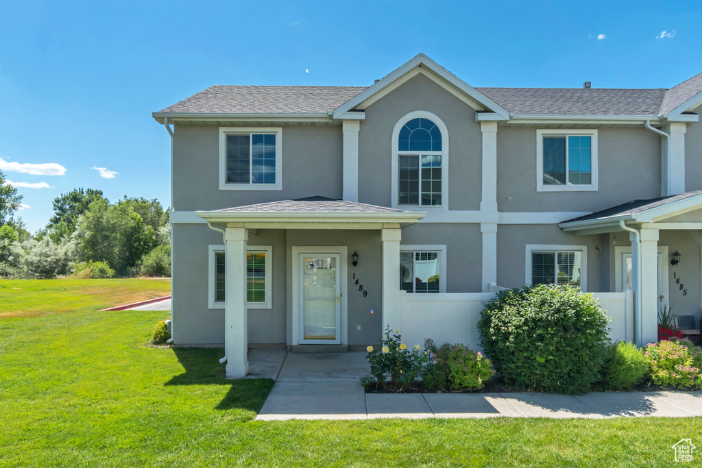 View of front of home featuring stucco siding and a front yard