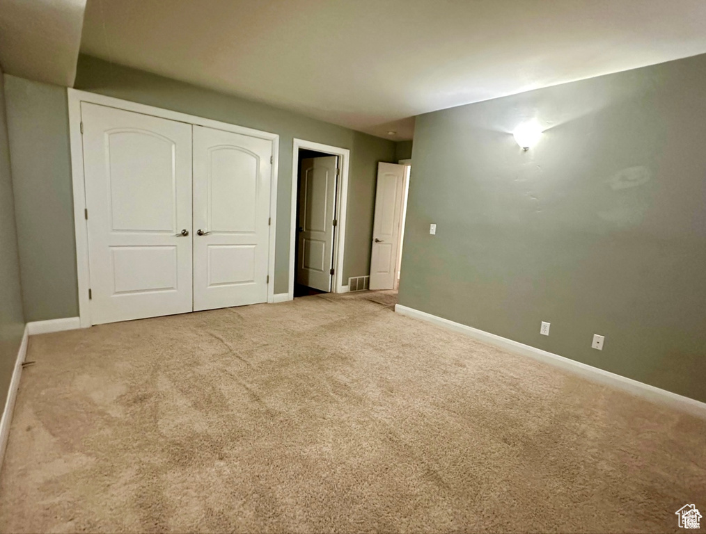 Unfurnished bedroom with carpet and a closet