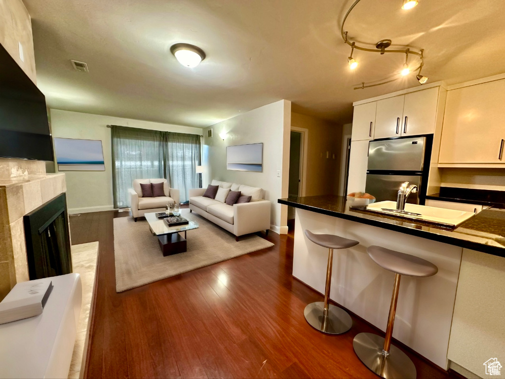 Living area with dark wood-type flooring and a tile fireplace