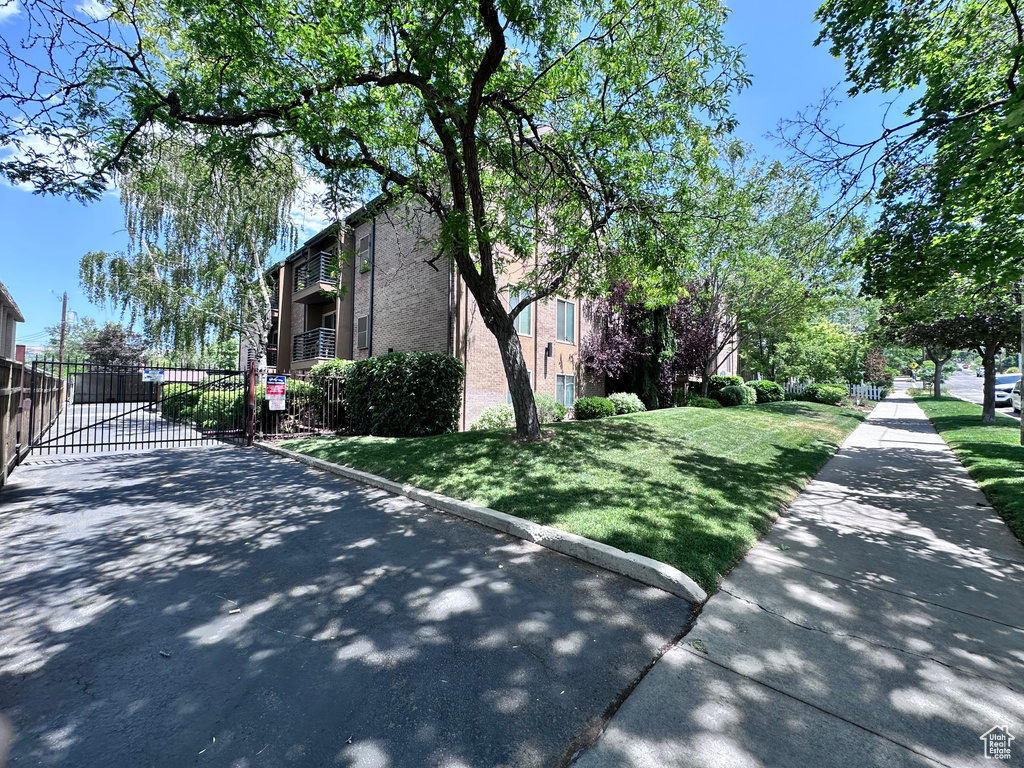 View of side of home featuring a gate and brick siding