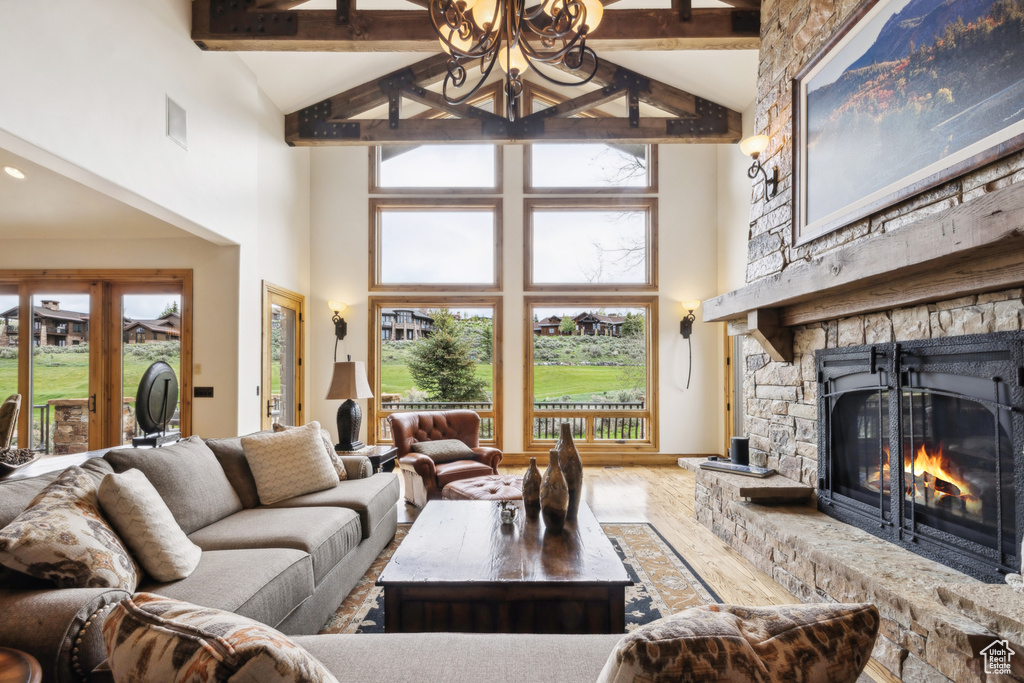 Living area with high vaulted ceiling, beam ceiling, a fireplace, and wood finished floors