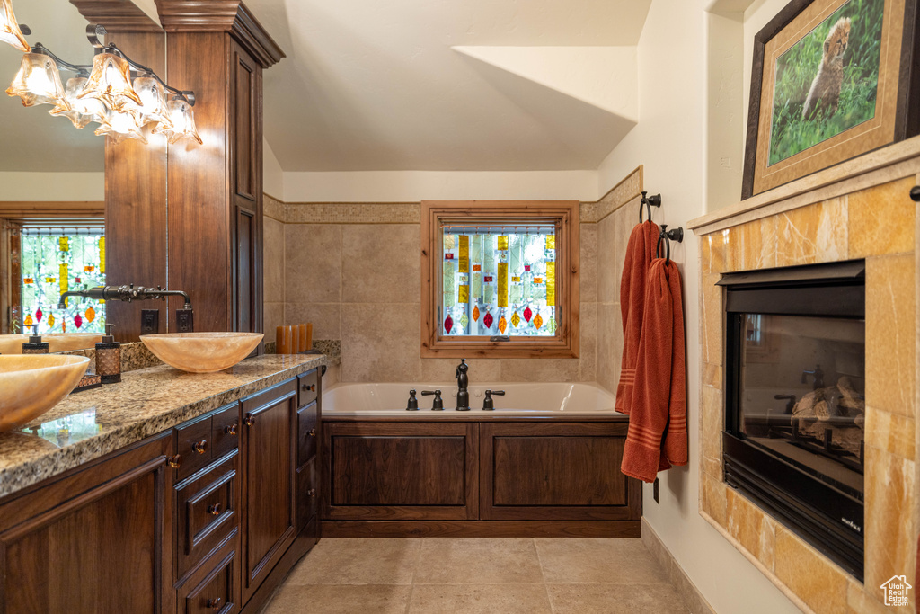 Bathroom featuring a bath, double vanity, and tile patterned floors