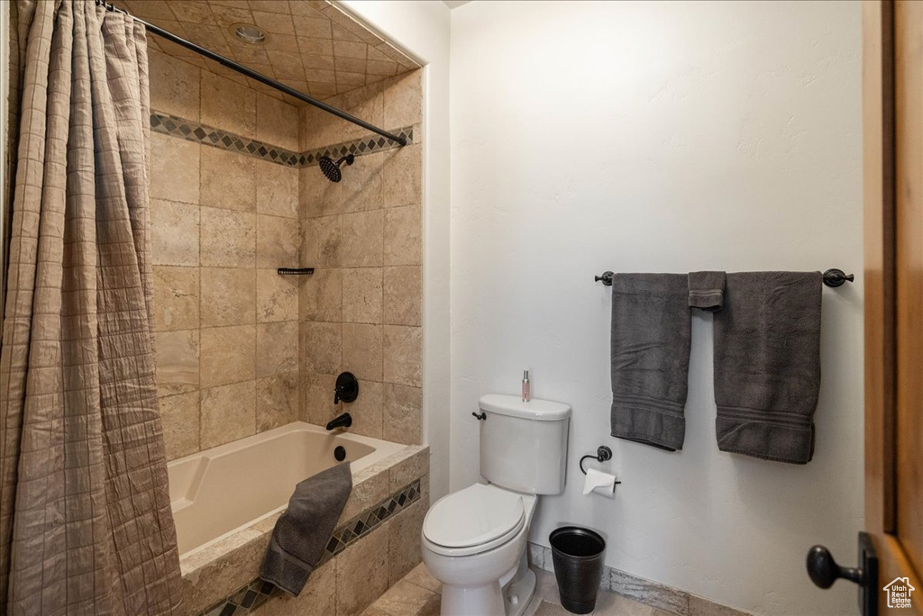Full bath featuring tiled shower / bath and toilet