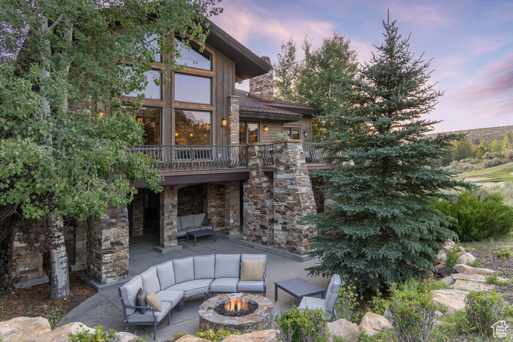 View of patio with an outdoor living space with a fire pit and a deck