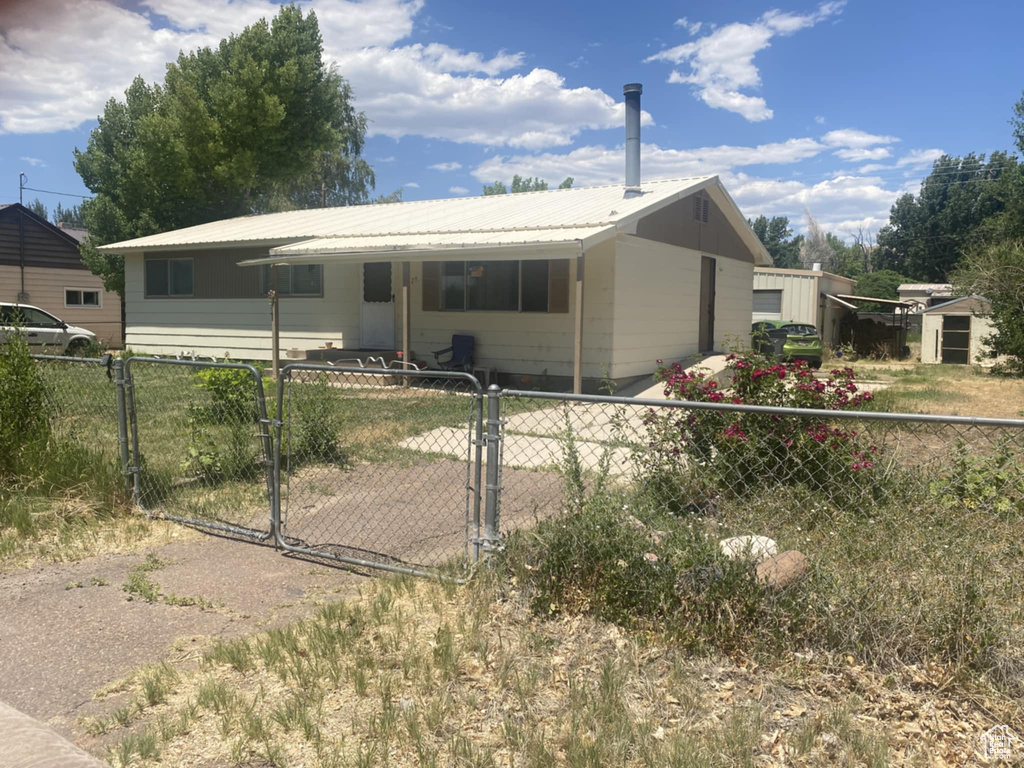Single story home featuring a gate and a metal roof