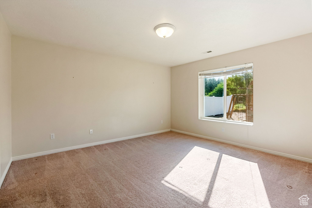 Empty room featuring light colored carpet