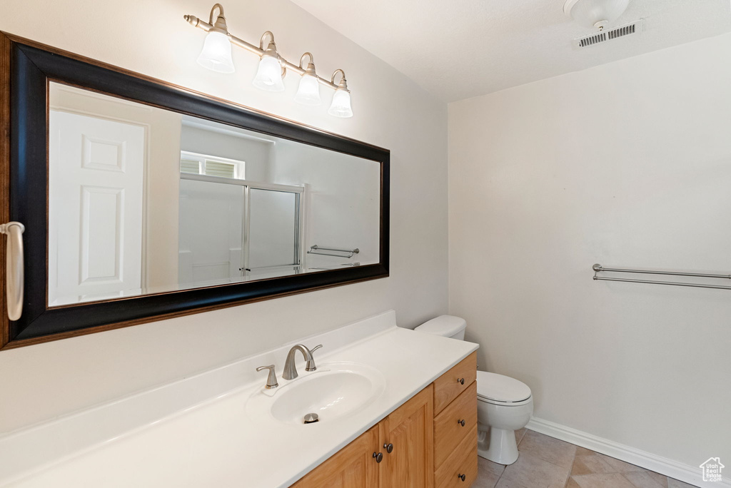 Full bath featuring vanity, an enclosed shower, and tile patterned flooring