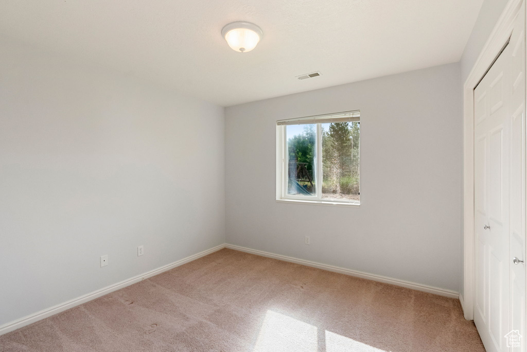 Unfurnished bedroom featuring light colored carpet and a closet