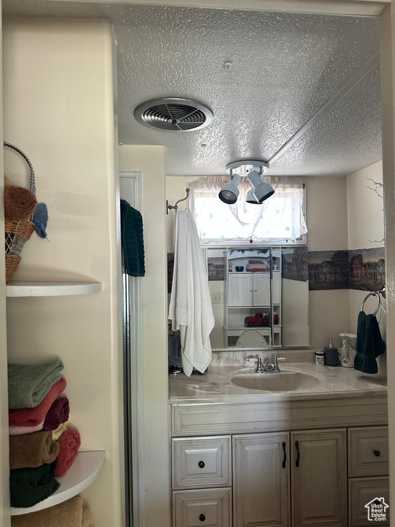 Bathroom with vanity and a textured ceiling
