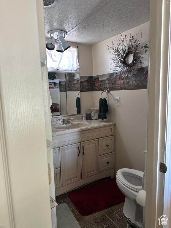 Half bath featuring vanity and a textured ceiling