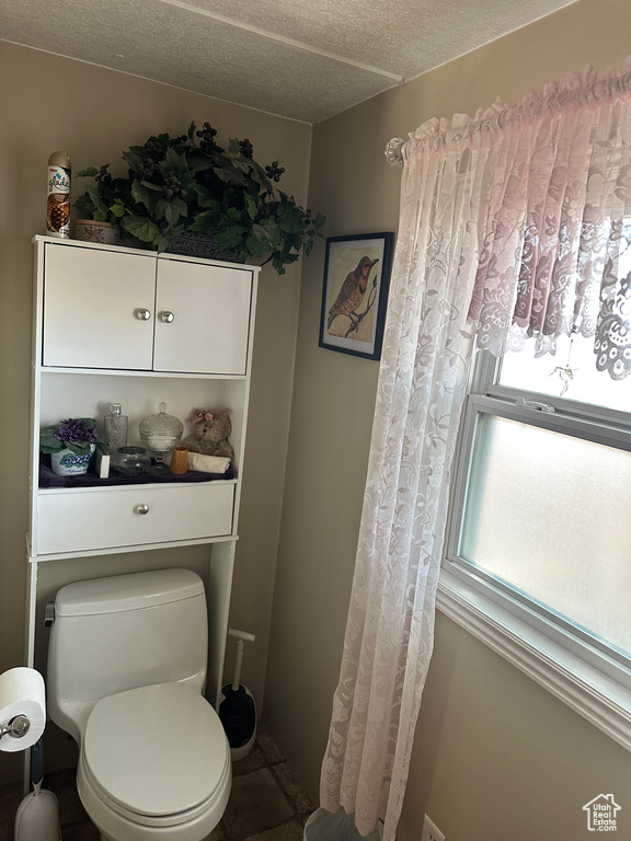 Bathroom with a textured ceiling and toilet
