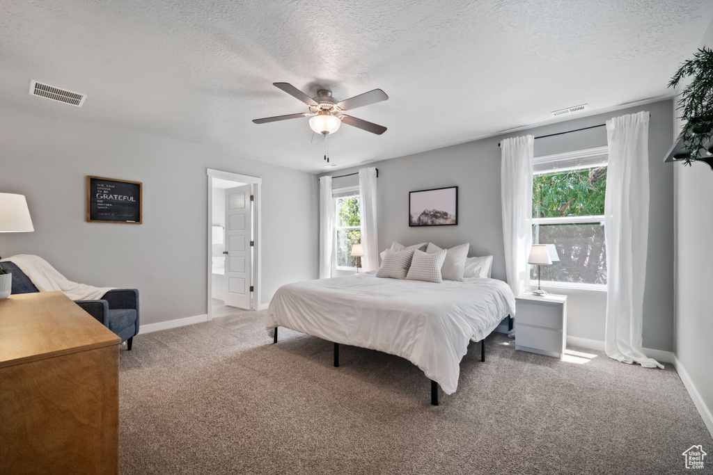 Bedroom with carpet flooring, a textured ceiling, and a ceiling fan