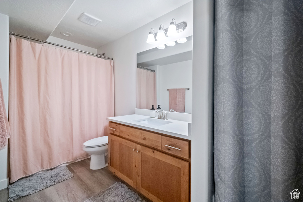 Full bath with wood finished floors and vanity
