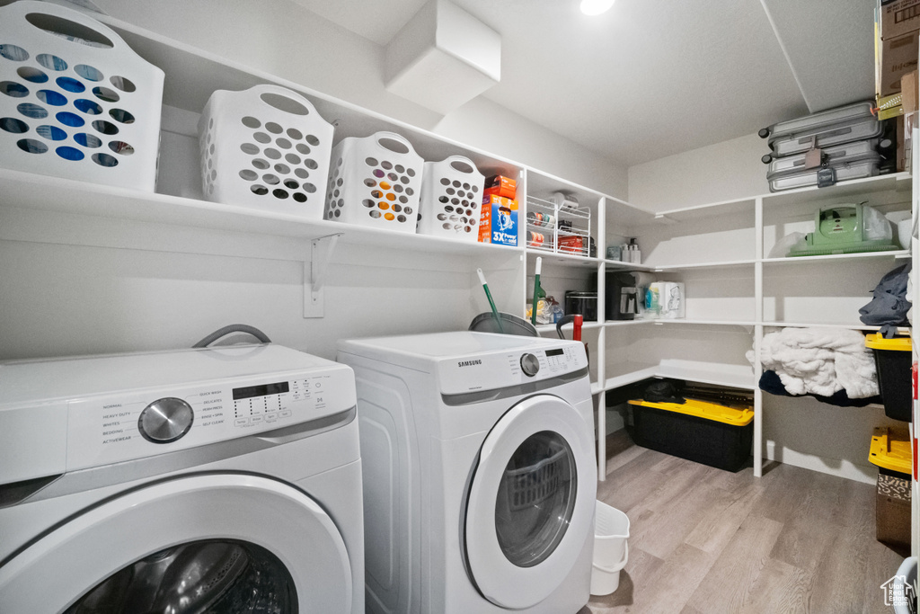 Laundry area featuring washer and dryer and light wood-type flooring
