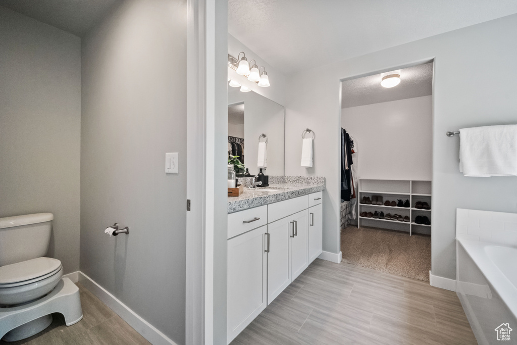 Bathroom featuring vanity, a garden tub, and a walk in closet