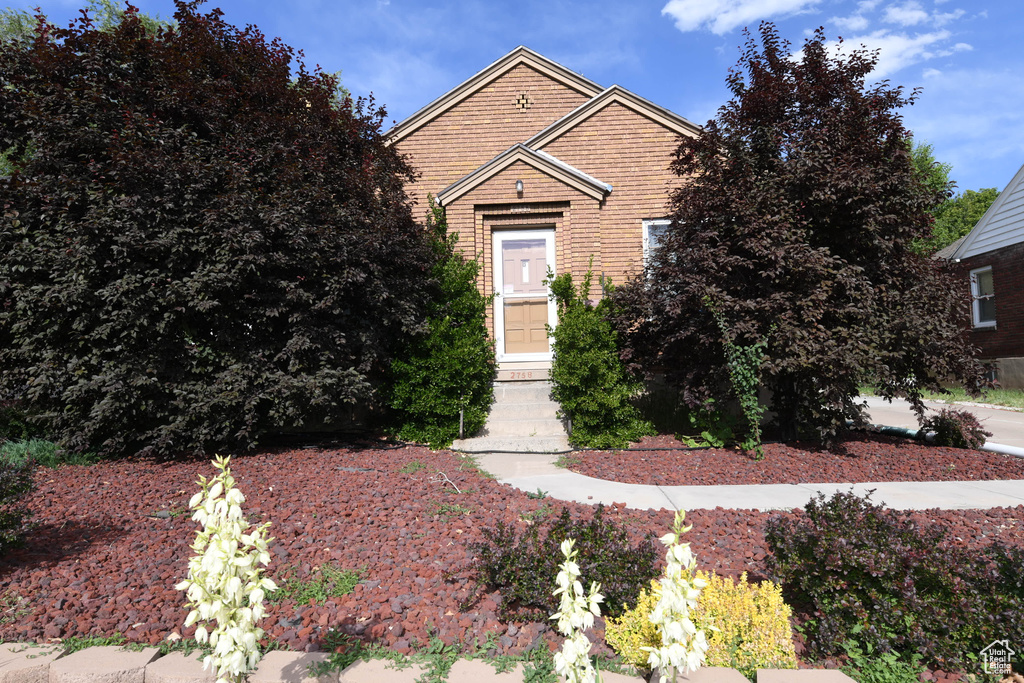 View of front of property with entry steps and brick siding