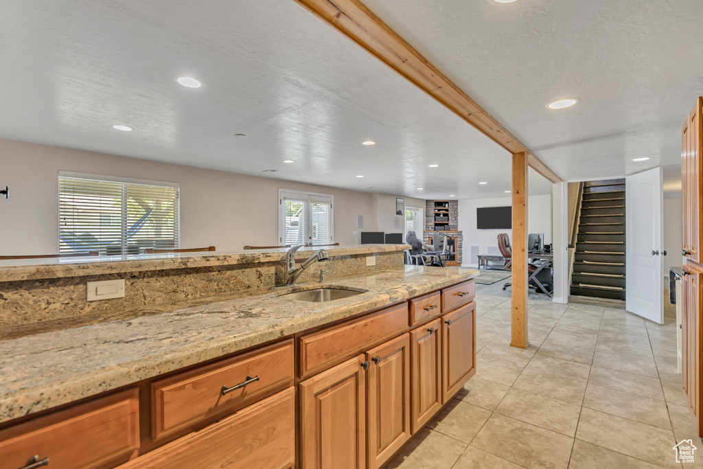 Kitchen featuring recessed lighting, light stone countertops, light tile patterned floors, and open floor plan
