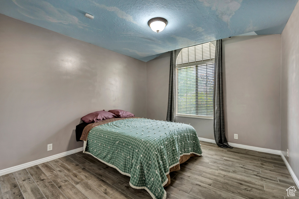 Bedroom with wood finished floors and a textured ceiling