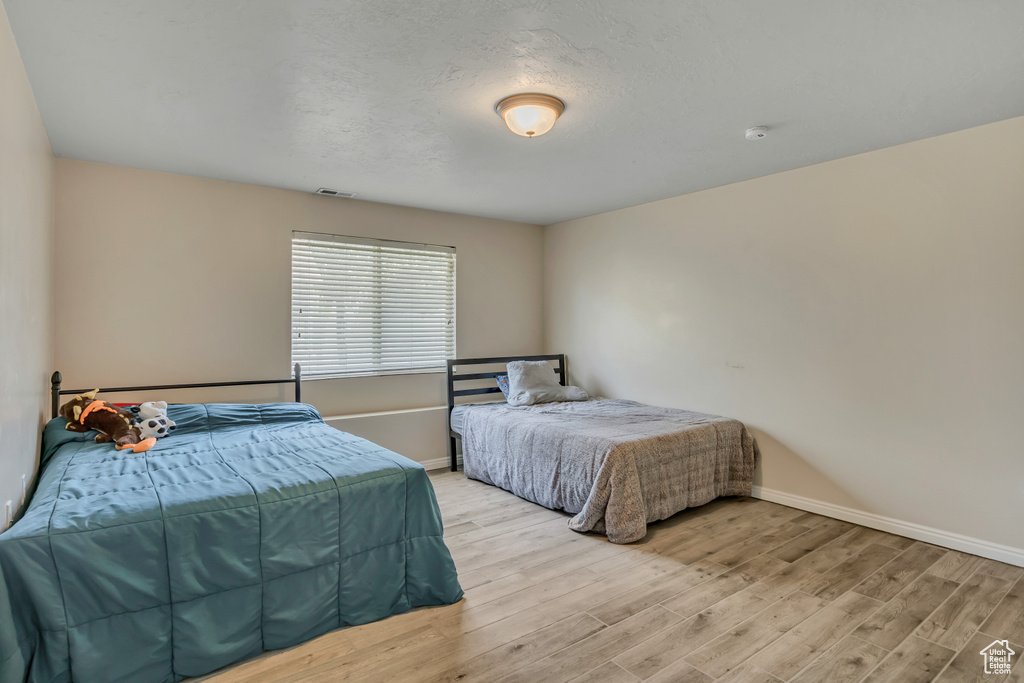Bedroom featuring light wood finished floors and baseboards