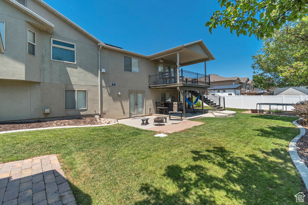 Back of property featuring stairs, stucco siding, a patio, an outdoor fire pit, and a wooden deck