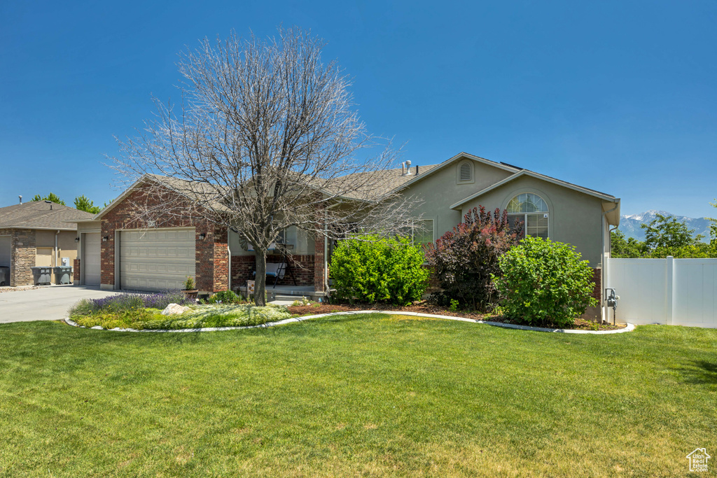 Ranch-style house featuring driveway, a garage, stucco siding, and brick siding