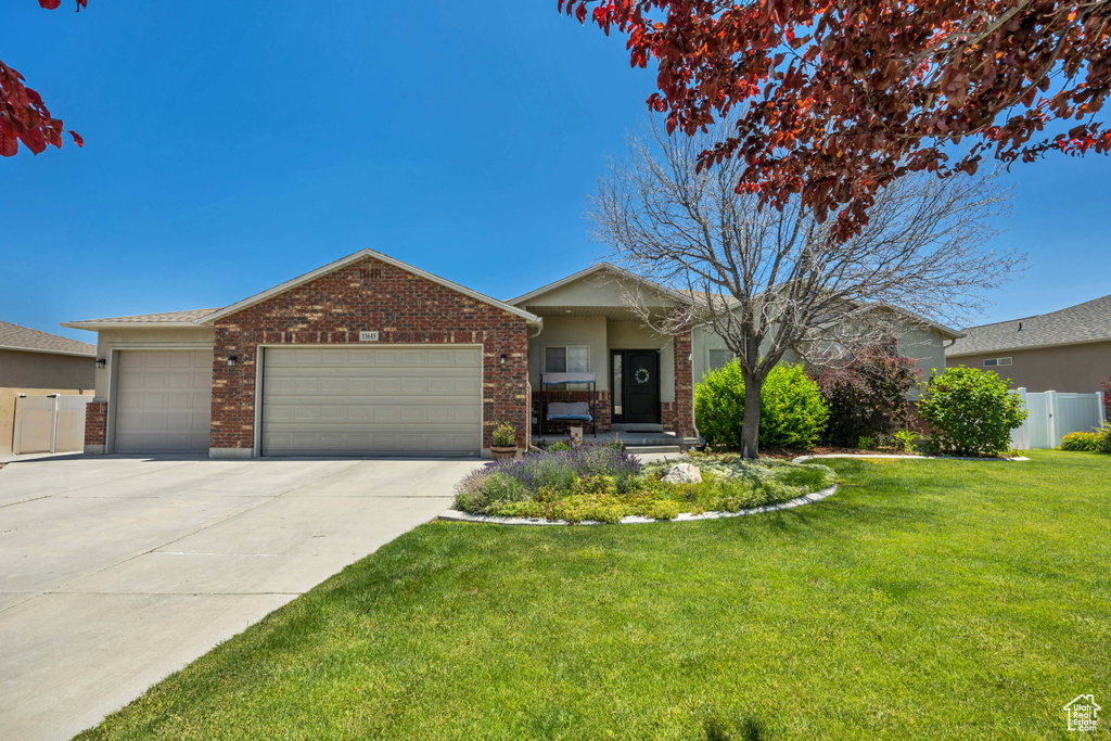 Single story home featuring an attached garage, concrete driveway, and brick siding