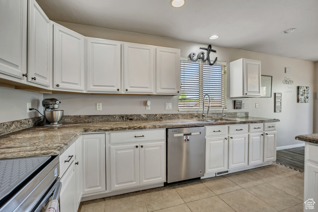 Kitchen with appliances with stainless steel finishes, white cabinets, light tile patterned floors, and recessed lighting