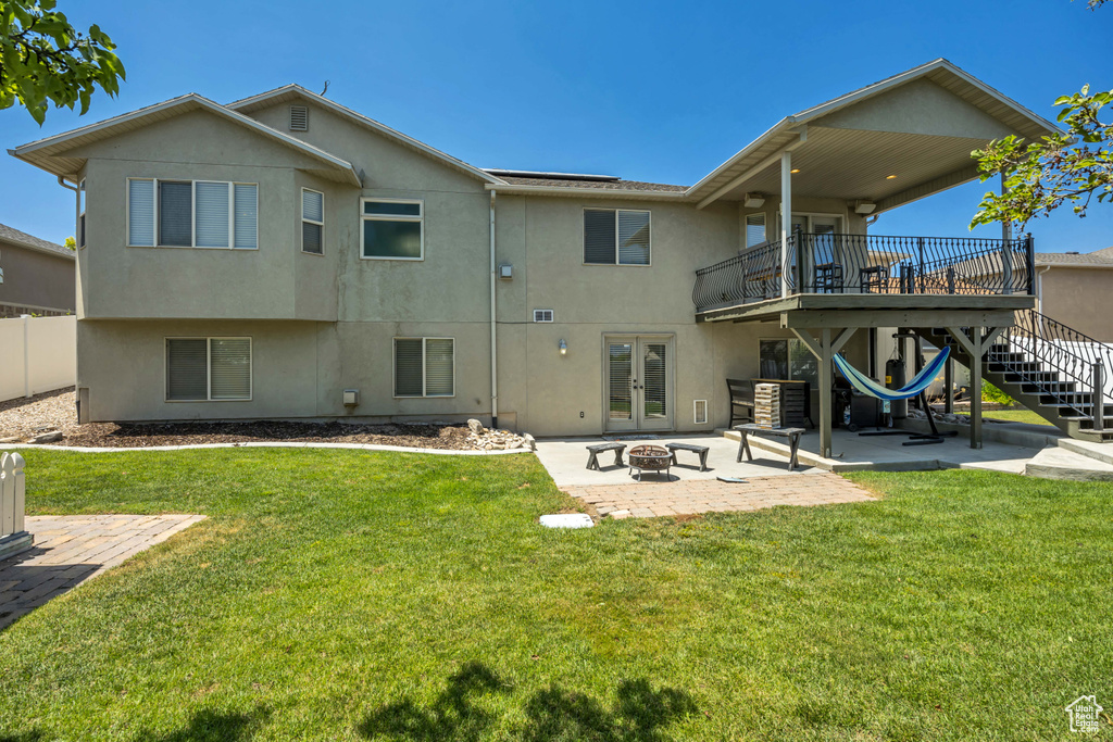 Rear view of house featuring french doors, an outdoor fire pit, a patio, and stucco siding