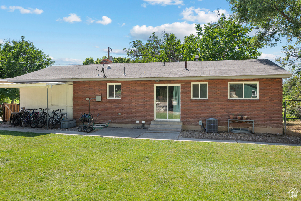 Rear view of house featuring entry steps, brick siding, and a patio area