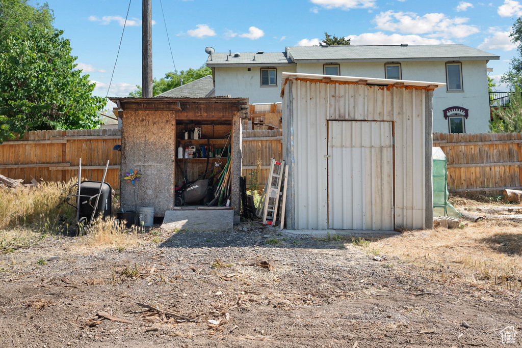 Rear view of house featuring a storage unit and a fenced backyard