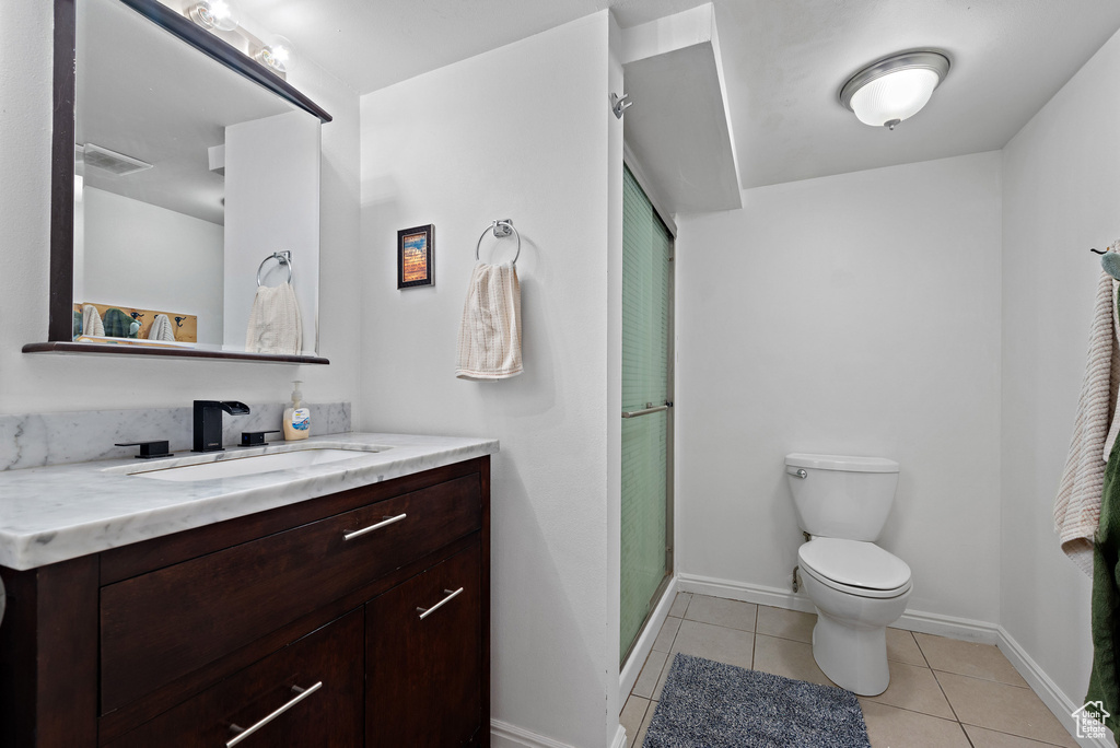 Bathroom with vanity, tile patterned floors, and a shower stall