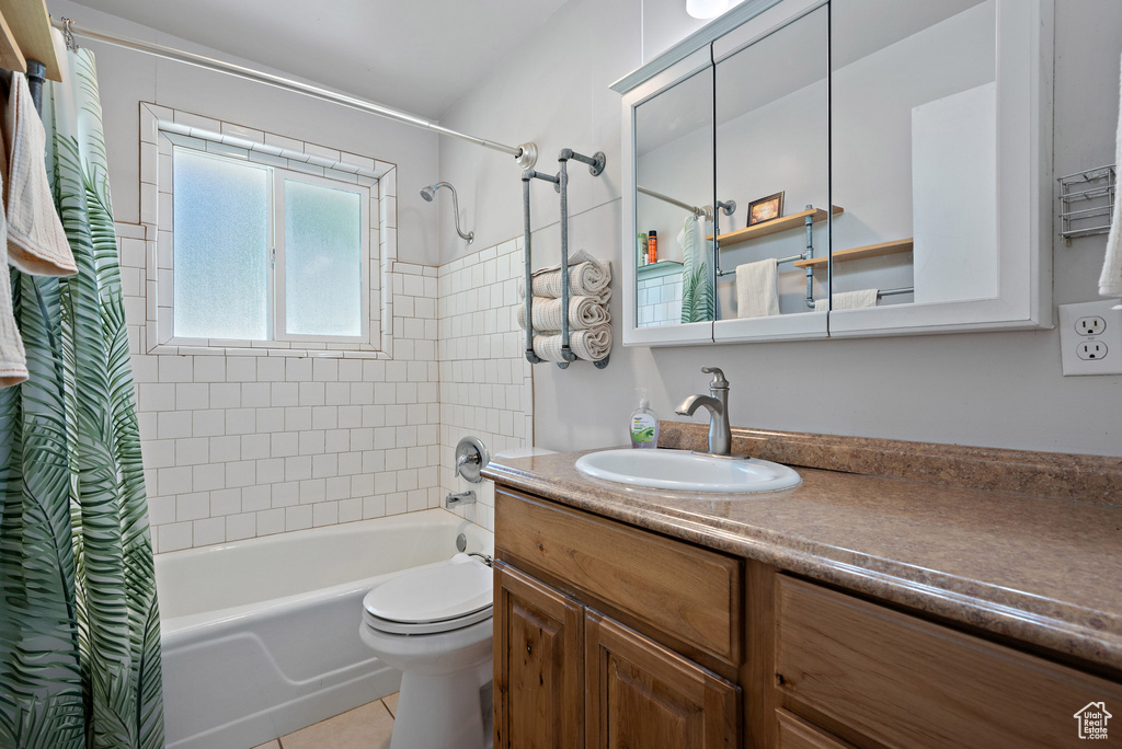 Bathroom featuring vanity, shower / bath combo with shower curtain, and tile patterned floors