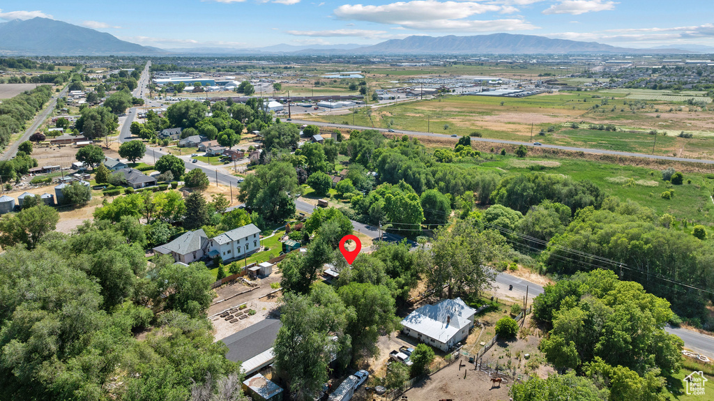 Aerial view of property and surrounding area featuring a mountainous background