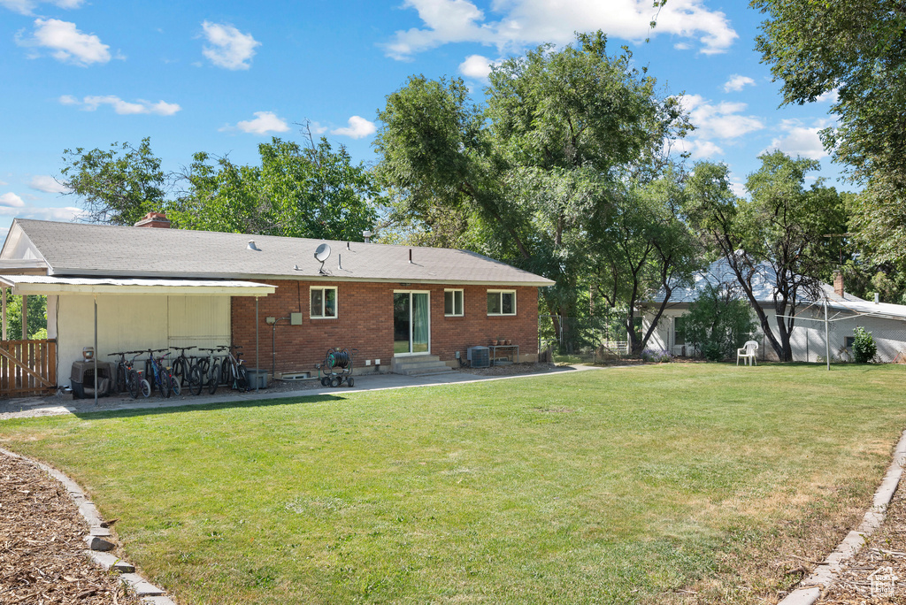 Rear view of house featuring entry steps, a patio area, and brick siding