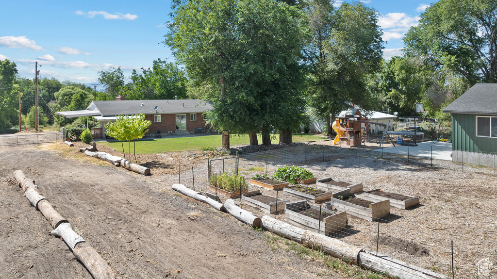 View of front facade with a vegetable garden and a playground