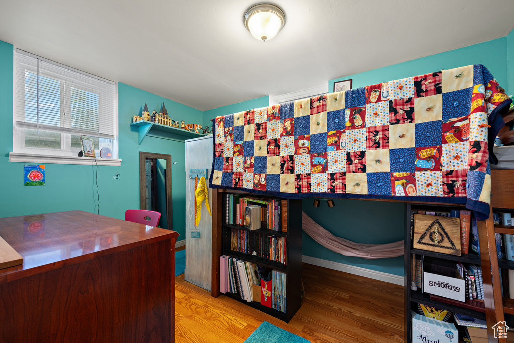 Bedroom featuring wood finished floors and baseboards