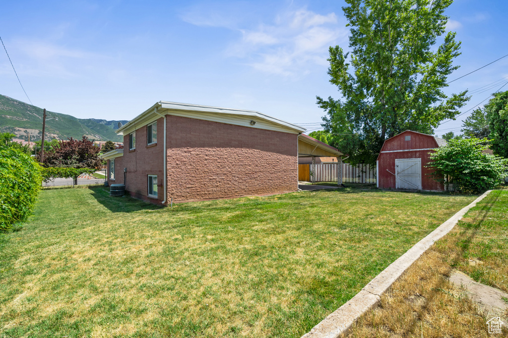 View of yard featuring a barn, an outbuilding, and a mountain view