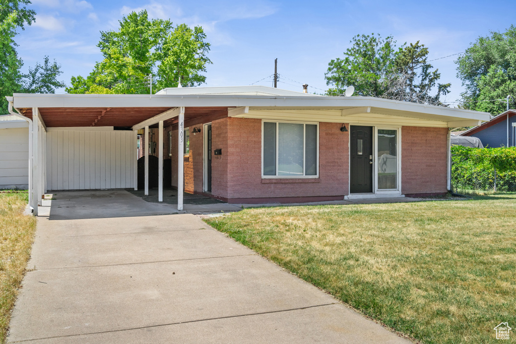 Ranch-style house featuring a front lawn, concrete driveway, and brick siding