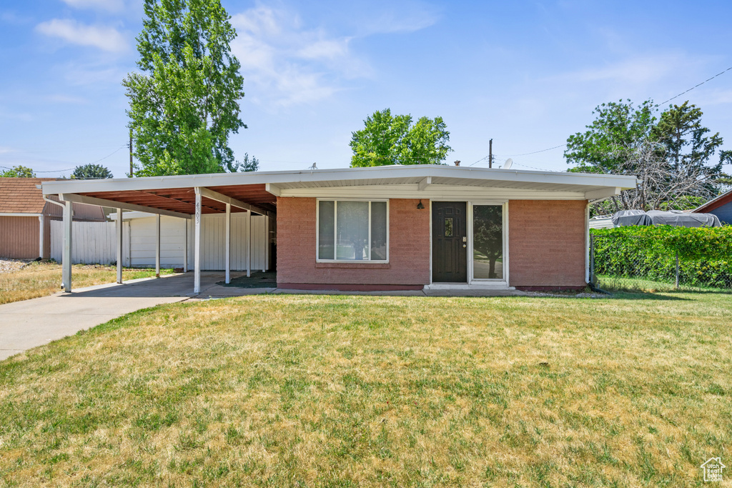 View of front of house featuring a carport, concrete driveway, and brick siding