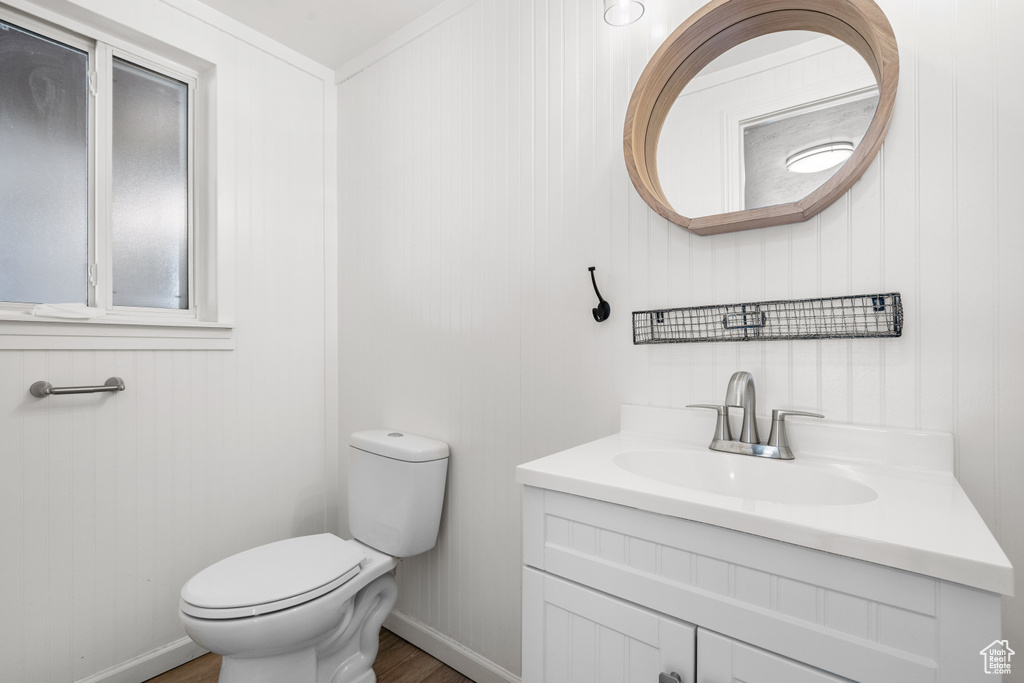 Half bath featuring wood finished floors and vanity