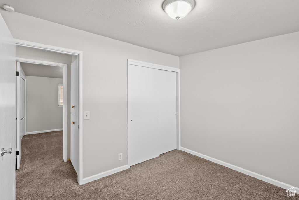 Unfurnished bedroom featuring carpet floors and a closet