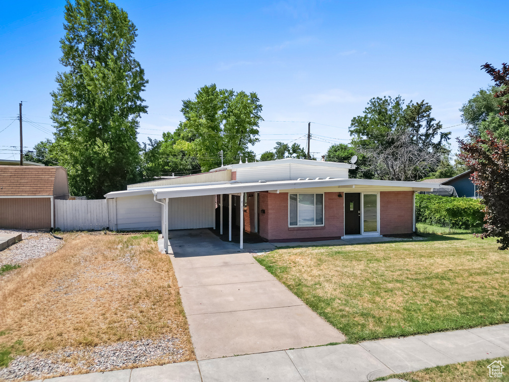 Mid-century home with concrete driveway, a carport, and brick siding