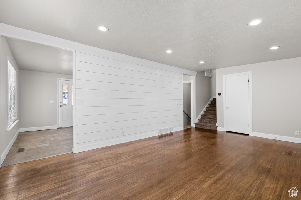 Spare room with stairs, recessed lighting, and wood finished floors