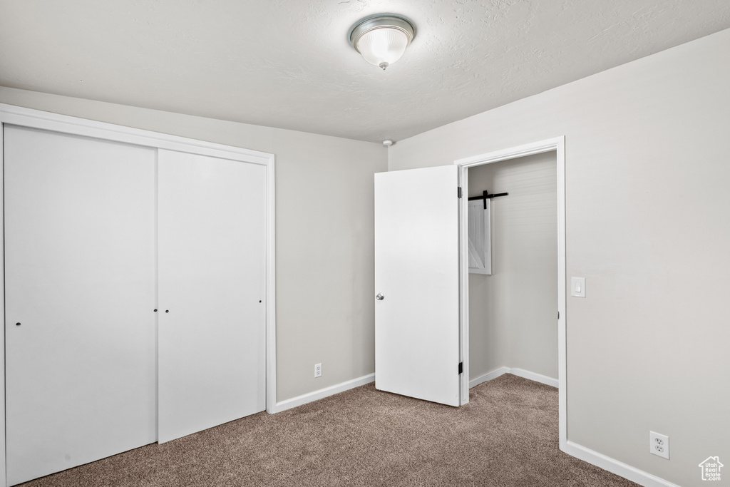 Unfurnished bedroom featuring carpet flooring and a closet