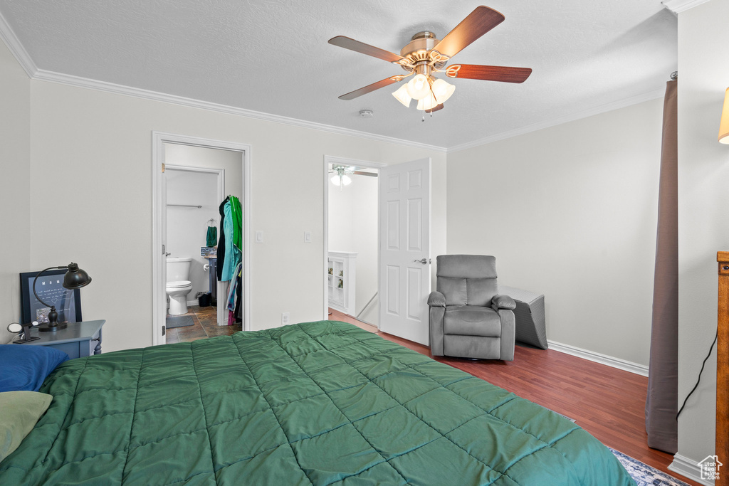 Bedroom featuring ornamental molding, wood finished floors, ceiling fan, and ensuite bathroom